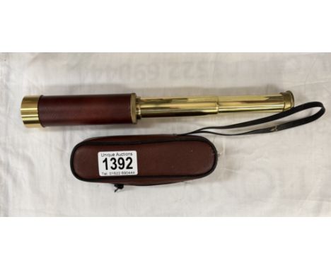 A leather bound brass telescope in carry case