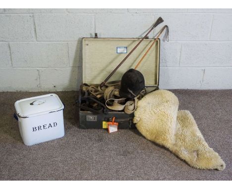 A case containing a quantity of horse tack and similar, including a leather riding crop, canvas lunging rein, bit and similar