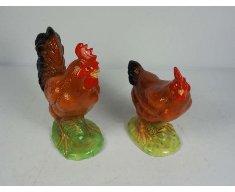 A pair of ceramic figures of a Cockerel and hen, both standing on green bases, Cockerel 24cm high (2)