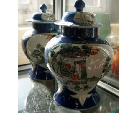 A pair of Chinese baluster form jars and covers depicting an outdoor Oriental landscapes, marked to the base with four charac