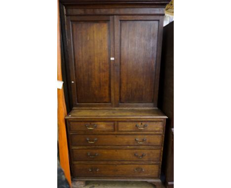 An 18th Century Georgian mahogany banded oak tall bookcase on chest, the moulded cornice above two recessed panelled doors en