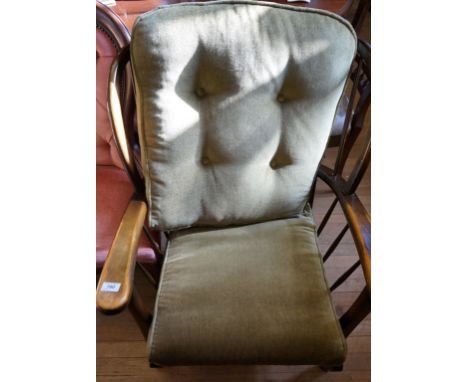 A reproduction stained spindle back armchair, upholstered in a green button back material.