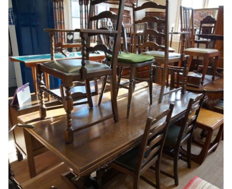 A reproduction oak dining suite comprising draw leaf refectory dining table, six ladder back dining chairs, having drop in se