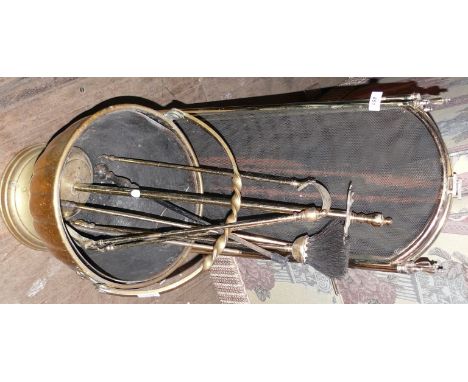 A vintage brass fireside suite, comprising a fire screen, companion set, coal bucket.