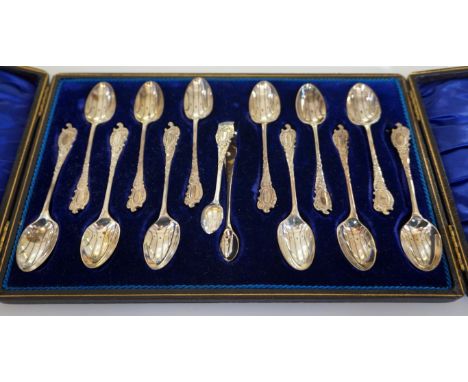 A cased set of twelve Sheffield hallmarked silver spoons and Sheffield hallmarked sugar nips with chased and engraved rococo 