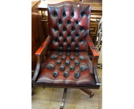 A good quality reproduction mahogany framed red leather button back swivel office chair.