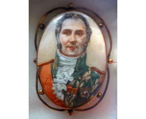 A Victorian glazed ceramic oval portrait brooch, depicting a Napoleonic officer  in uniform and orders, within ornate rolled 