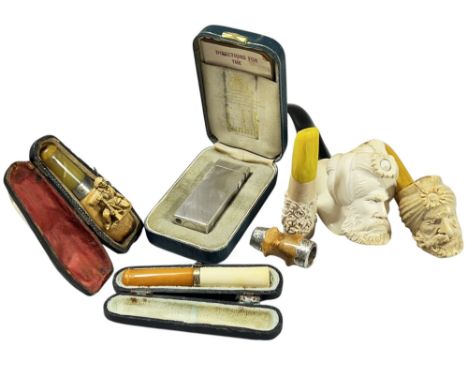 Two Meerschaum pipes both with Turk‘s head bowls, and three further cheroot holders, together with a Dunhill lighter with eng