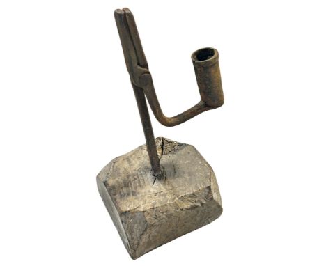 A George III wrought iron rushlight and candleholder, probably Mid Wales , with a long jaw on a faceted oak base , 25 cm high