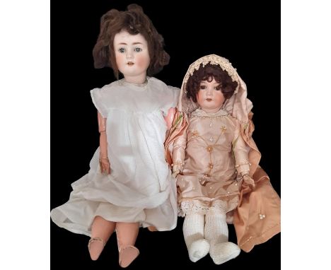 Two early 20th century German bisque head dolls both with open mouth with teeth and jointed composition body; the taller doll
