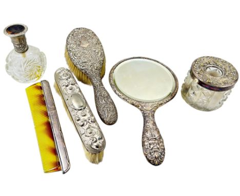 A silver-backed hand mirror, clothes and hairbrush, a comb and two similar lidded glass bottles