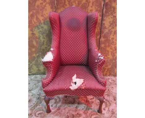 An antique Queen Anne style wing back armchair with shaped outline, raised on cabriole forelegs with carved detail (af for re