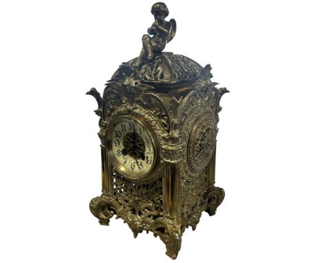 A continental cast and pierced polished brass lantern type clock with opaque glass chapter ring populated with black gothic A