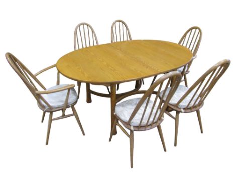An Ercol light elm Saville D end extending dining table with additional bi-folding leaf raised on simple turned tapered and f