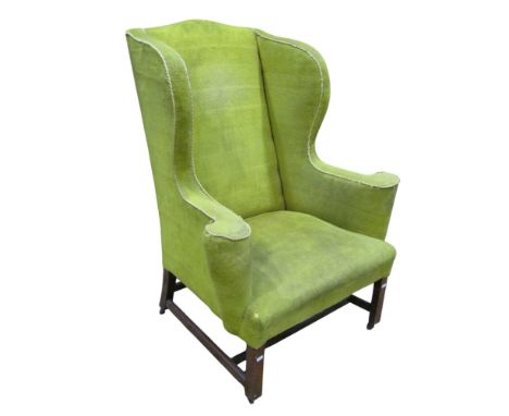 A Georgian wing armchair with shaped outline, green upholstery and square cut mahogany supports and stretchers, 116 cm height