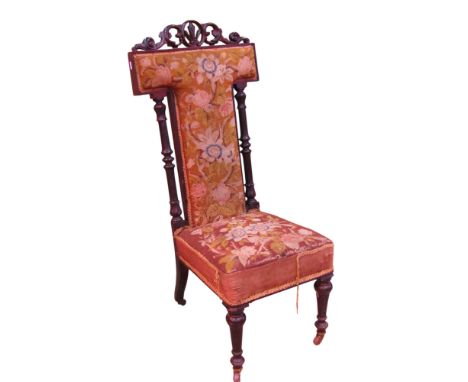 A Victorian prie-dieu with floral tapestry upholstered seat and T shaped back within an ebonized showwood frame 