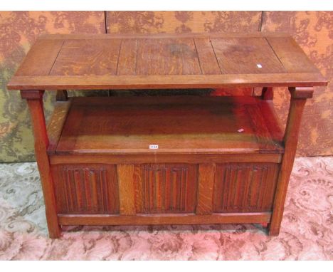 An oak monks bench with sliding top over a hinged box seat with linen fold panels, 72 cm high x 107 cm x 51 cm