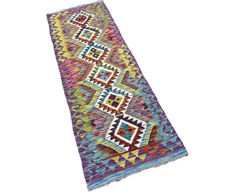 A Chobi kilim runner with a central row of interlocking stepped medallions with hints of purple, 198cm x 66cm