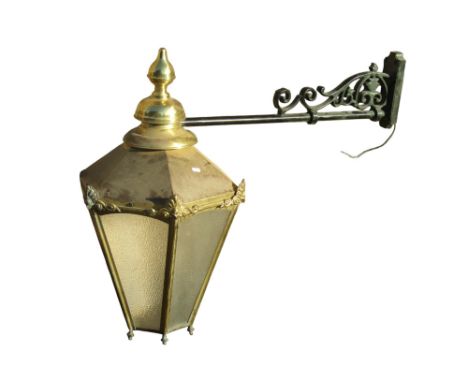 A large reproduction exterior lantern of hexagonal tapered form, with fixed adjoining wall bracket, the hood 80cm high x 50cm