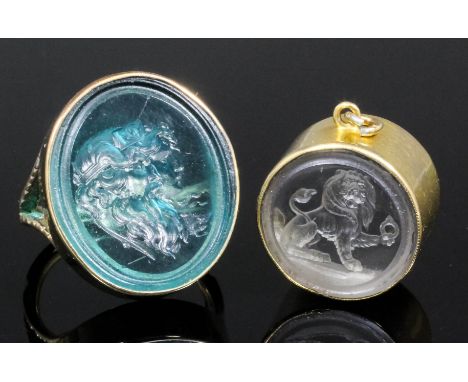 An early 19th Century gold coloured metal mounted pale blue glass set intaglio seal ring, the face cut with the head of a cla