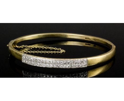 A modern 9ct gold stiff bangle, the central face pave set with forty small rose cut diamonds (gross weight 13 grammes)