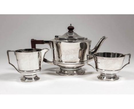 An Edward VIII silver three piece tea service with plain circular bodies and moulded girdles, each on twelve sided base, comp