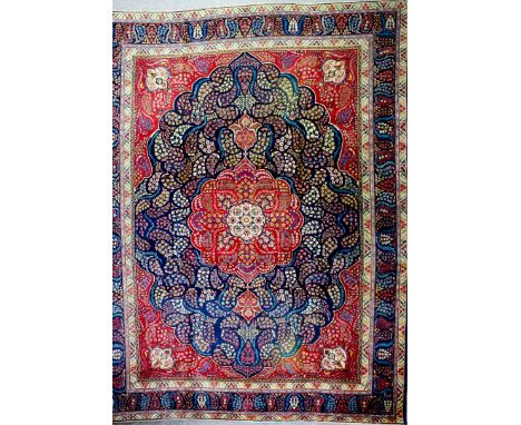 A Tabriz carpet woven in colours with a bold central lobed medallion, the field filled with gold boteh style floral motifs on