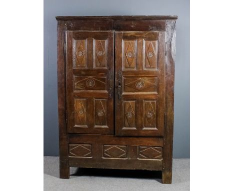 An 18th Century Breton panelled oak armoire with moulded cornice, fitted one shelf enclosed by a pair of doors with five pane