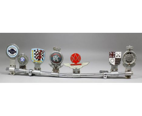 Seven British enamelled car badges mounted to bar, including - "Aston Martin Owner's Club", and a Royal Automobile Club Full 