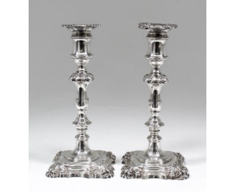 A pair of George IV silver pillar candlesticks of mid 18th Century design with square sconces and square moulded bases with b