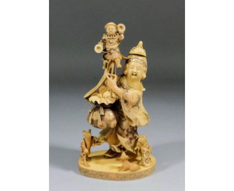 A fine Japanese carved ivory okimono of Jourojin dancing and wearing a long nosed tengu mask and holding aloft a puppet of a 