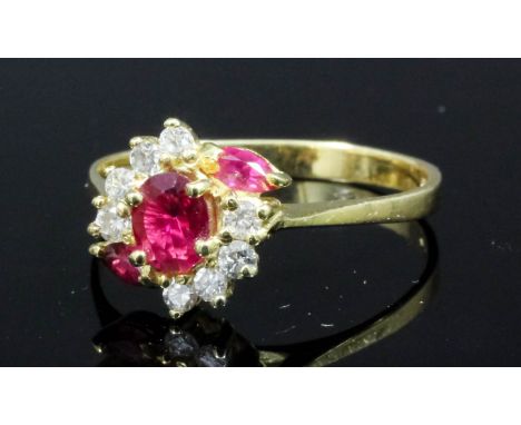 A modern 18ct gold mounted ruby and diamond set ring, the central oval cut ruby approximately .20ct bordered by two smaller r