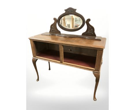An oak side table fitted with shelf beneath on cabriole legs, width 104 cm together with an associated swing mirror 