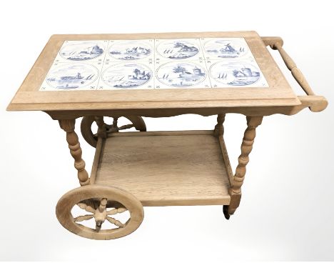 A Dutch oak and delft tile inset drinks trolley, length 83 cm.