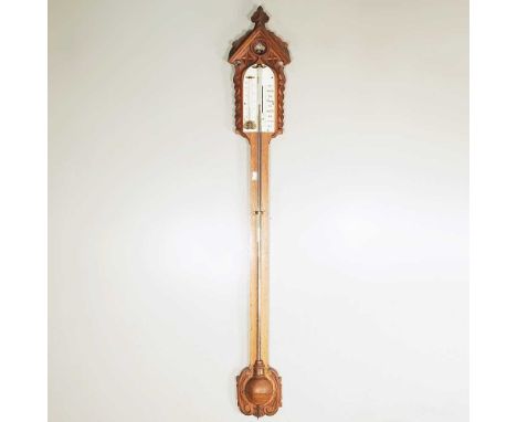 A Victorian Gothic revival oak cased stick barometer, with an ivory dial and exposed tube, 107cm high. Note: a non-transferab