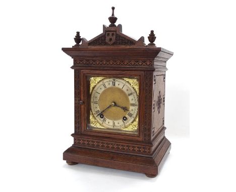 Oak ting-tang bracket clock with W &amp; H movement, the 5" square brass dial within a stepped geometrically carved case surm