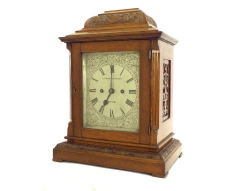 English oak double fusee mantel clock, the 6" engraved dial signed J.J Stockall &amp; Sons Ltd. London within a carved steppe