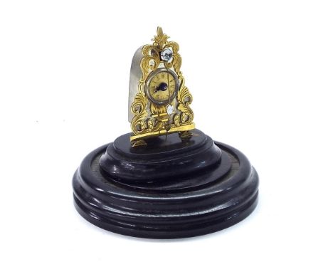 Miniature gilt metal Zappler timepiece, upon an ebonised base beneath a circular dome, clock 3" high