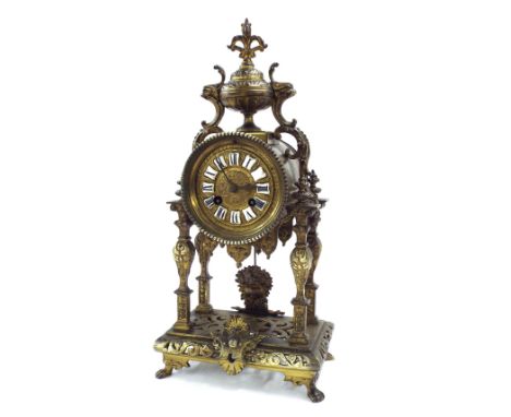 Gilt metal two train portico type mantel clock striking on a bell (missing), the 3.5" repousse dial with Roman cartouche enam