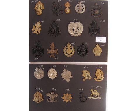 A collection of x24 original antique and vintage London Regiment British Army military uniform cap badges. Badges present for