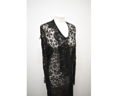 A black lace 1930s dress, having full length sleeves gathering into a pointed cuff and sash detail to bodice, no fastening.