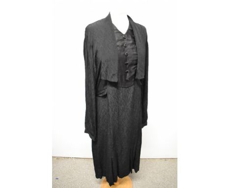 A 1930s black textured crepe day dress, having draped collar, integrated modesty panel, full length sleeves, half belt to wai