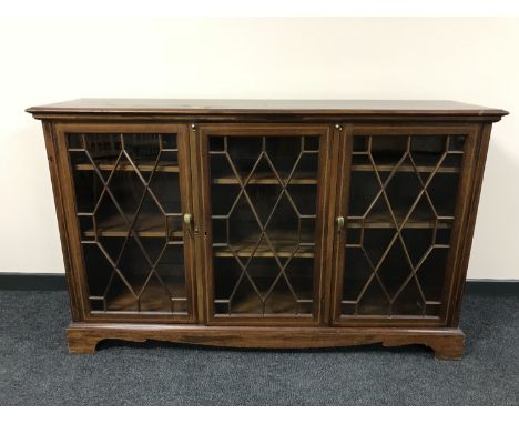 A late Victorian inlaid mahogany triple door bookcase on bracket feet 