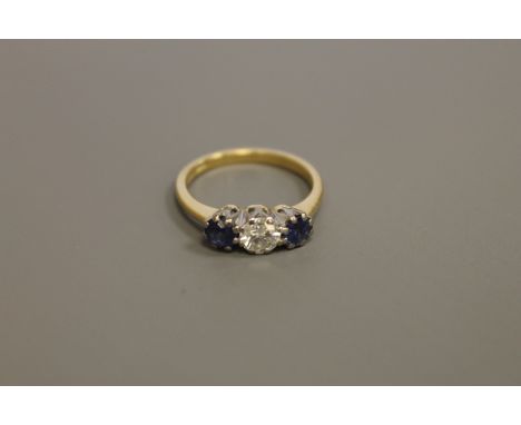 An 18ct gold three stone sapphire and diamond ring, the central stone weighing approximately 0.5 carat, size M CONDITION REPO