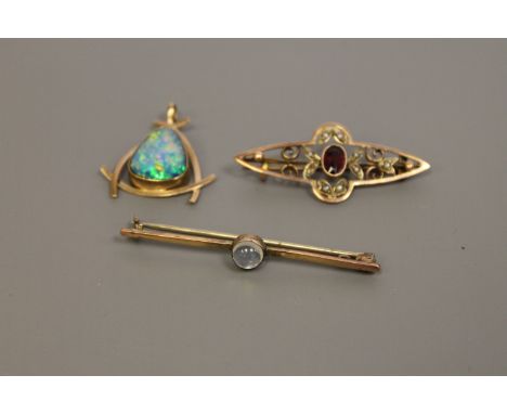 Three gold brooches/pendants to include a moonstone bar brooch, an opal pendant and a garnet and seed pearl and garnet brooch