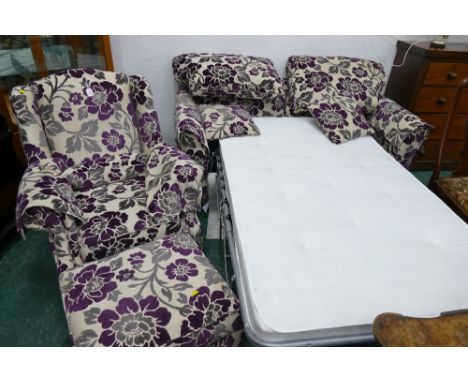 Purple and grey floral upholstered two piece suite comprising armchair with storage footstool and two seater sofa bed