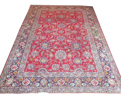 FINE ANTIQUE PERSIAN KASHAN CARPET, 373cm x 276cm, all over palmette and vine design on a ruby field inside multiple correspo