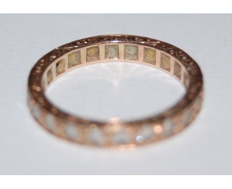 A yellow metal and white sapphire set eternity ring 