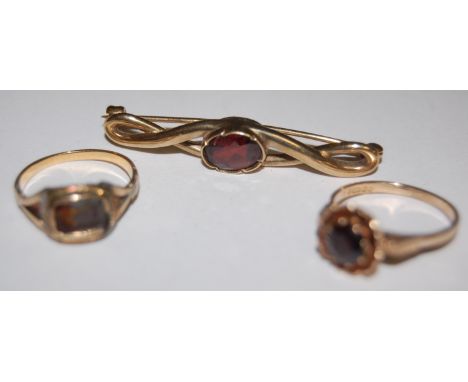 A 9ct gold garnet set bar brooch; a ladies 9ct gold garnet set dress ring; and one other (3) 