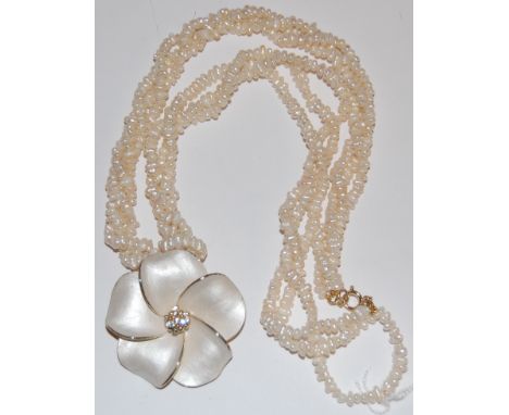A modern rice pearl triple string necklace with enamel set flower head pendant 